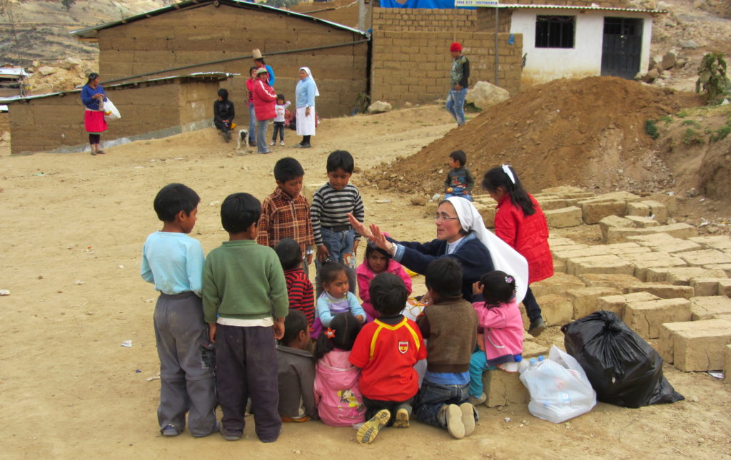Suora con bambini in Perù