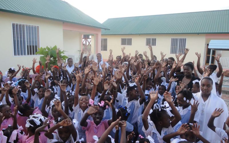 gruppo di bambine e ragazze haitiane con le braccia alzate
