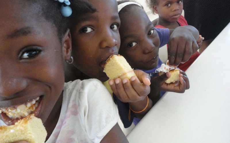 Bambine mentre mangiano una torta