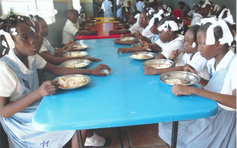 bambine in una mensa ad Haiti mentre mangiano del riso